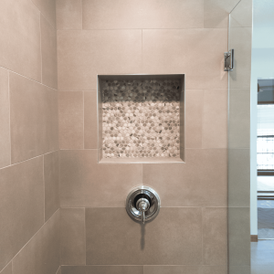 Elegant shower niche featuring pebble tile design in a contemporary bathroom, demonstrating expert renovation services by Days Home Solutions, perfect for enhancing bathroom aesthetics and functionality. Shower niche with pebble tile accent in beige bathroom tiles, modern shower design, sleek finish, focal point in bathroom renovation, Days Home Solutions.
