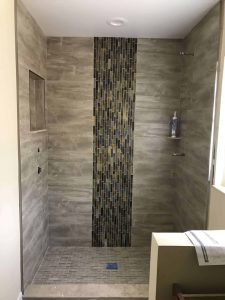 Elegant gray and mosaic tile shower for bathroom updates, highlighting professional tiling and renovation services by Days Home Solutions. Modern walk-in shower with stylish gray tile walls and a vertical mosaic accent strip, showcasing bathroom renovation and custom tile design by Days Home Solutions.