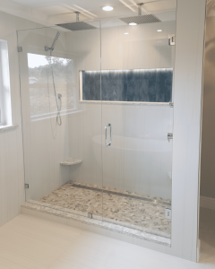 Luxurious walk-in glass shower with pebble tile floor, built-in bench, and modern fixtures, perfect for a stylish bathroom remodel and home renovation. Spacious modern walk-in glass shower with pebble tile floor and built-in bench, featuring sleek fixtures and natural light for a luxurious bathroom upgrade.