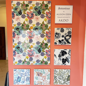 Display of vibrant botanical stained glass art pieces created by Allison Eden, featuring colorful floral and nature motifs, perfect for home or commercial decor. Vivid floral stained glass art display by Allison Eden for AKDO, showcasing colorful botanical and nature-inspired glass design pieces.